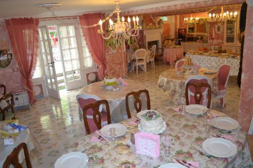 a room with tables and chairs with a cake on them at La maison delle favole in Desenzano del Garda