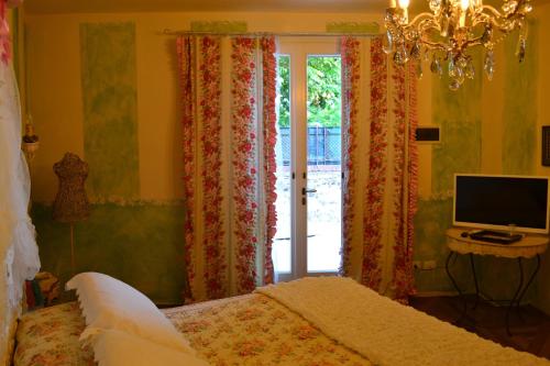 a bedroom with a bed and a tv and a window at La maison delle favole in Desenzano del Garda