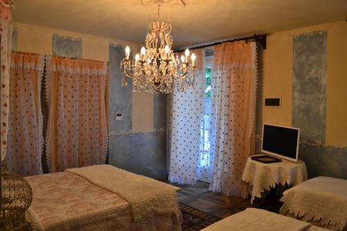 a bedroom with a chandelier and a computer on a table at La maison delle favole in Desenzano del Garda