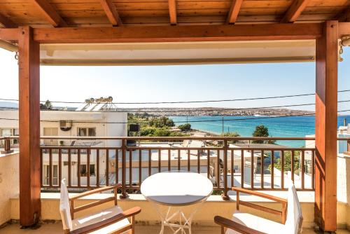 balcone con tavolo, sedie e vista sull'oceano di Simon Studios and Apartments a Sitia