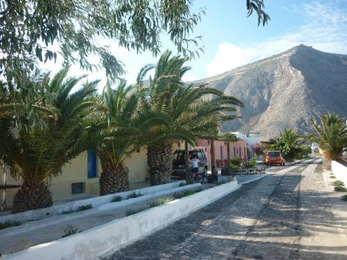 una calle con palmeras frente a una montaña en Agios Antonios, en Perissa