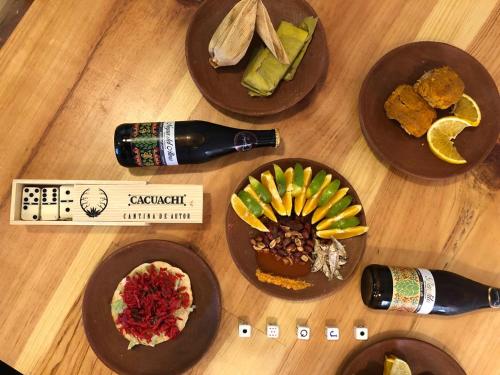a table with plates of food and a bottle of wine at NaNa Vida Hotel Oaxaca in Oaxaca City
