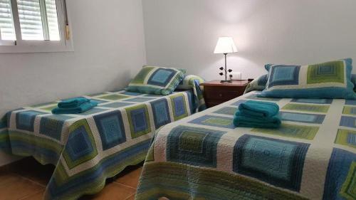 Dos camas una al lado de la otra en una habitación. en El chalet del Mar, en Chiclana de la Frontera