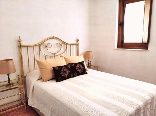 a bedroom with a bed with white sheets and pillows at La casa de Tentenecio in Salamanca