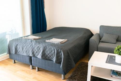 um quarto com uma cama e um sofá em City center brand new studio, parking em Oulu