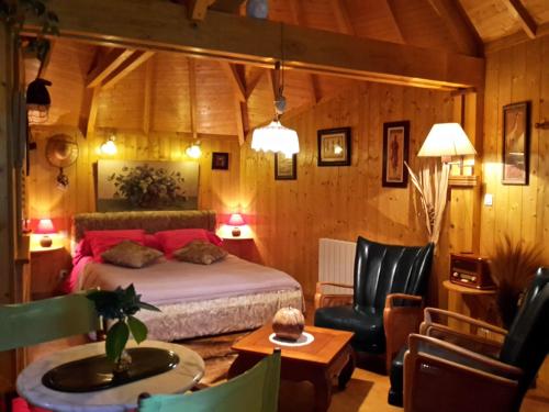 1 dormitorio con 1 cama, mesa y sillas en La Cabane de Cécile-la Hutte, en Étretat