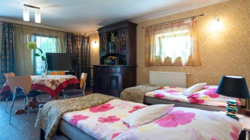 a bedroom with two beds and a table and a desk at Apartament Przy Słonecznej in Mysłakowice