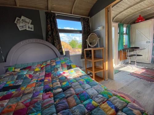 een slaapkamer met een bed met een kleurrijke quilt bij De Ganz in Grafhorst