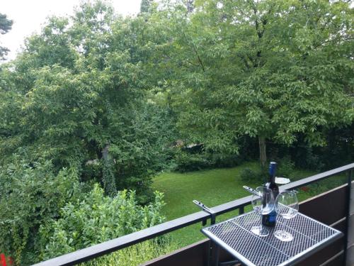 a table with wine bottles and glasses on a balcony at Claar Ferienwohnung Lindau Bodensee in Lindau