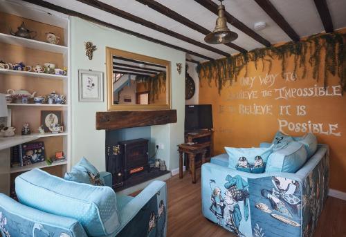 a living room with two blue chairs and a fireplace at Violets Wonderland Cottage in Llandudno
