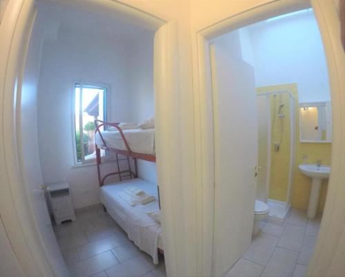 Itaca Residence Marsala في مارسالا: غرفة بسريرين بطابقين وحمام