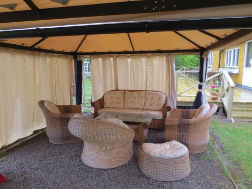 a group of wicker chairs and a table under a tent at Furuliden Country Inn in Vittsjö