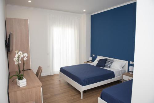 1 dormitorio azul con 1 cama con pared azul en B&B La Piazzetta en Pompei