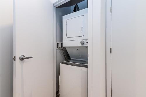a kitchen with a washer and dryer in a room at Wonderful New Studio close to Mount Royal By Den Stays in Montréal