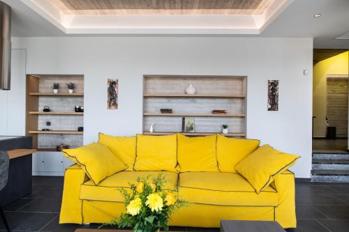 a yellow couch in a living room with yellow pillows at Ionian Grand Villas - Villa Estella in Lygia