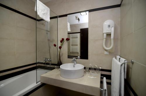uma casa de banho com um lavatório, um chuveiro e uma banheira em Ice Angels Hotel em Borovets