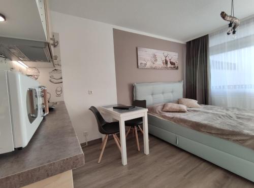 - une chambre avec un lit, une table et un réfrigérateur dans l'établissement Studio 20qm mit Balkon und Innenpool - 22010, à Schluchsee