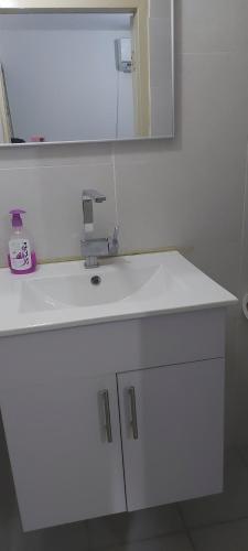 a bathroom with a white sink and a mirror at פרטיות וחוויה אצל יעקב וירדנה Privacy and an experience at Jacob and Yardena in Afula
