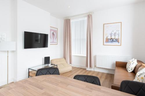 a living room with a table and a couch at Banc Apartment 1 in Porthmadog