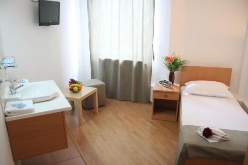 a hospital room with two beds and a sink at Hotel Sir Gara de Nord in Bucharest