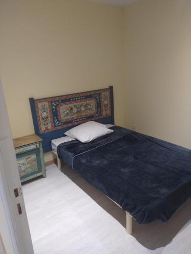 1 dormitorio con 1 cama con edredón azul en Gîte campagne, en Cours la Ville