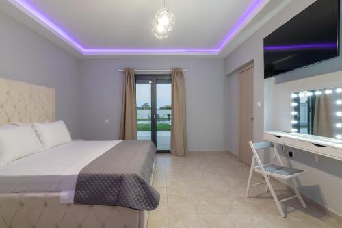 a bedroom with a bed and a desk and a television at Nimar Villa in Gaïtánion