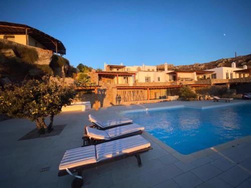 a group of lounge chairs next to a swimming pool at Luxury Sunset in Mikonos