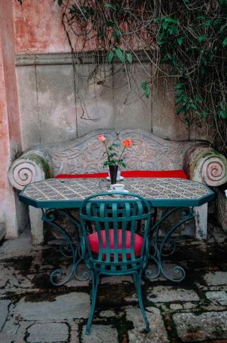 a table and a chair with a vase on it at Meson Panza Verde in Antigua Guatemala