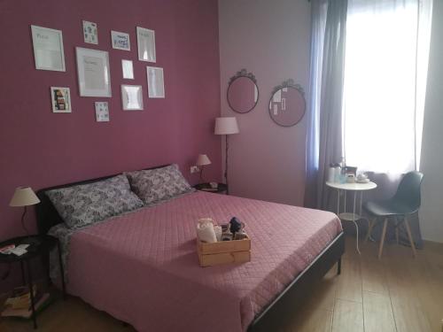a bedroom with a pink bed with a box on it at B&B Casa Caterina in Milan