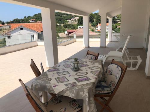 a dining table and chairs on a porch with a view at Apartments Palit Rab in Rab