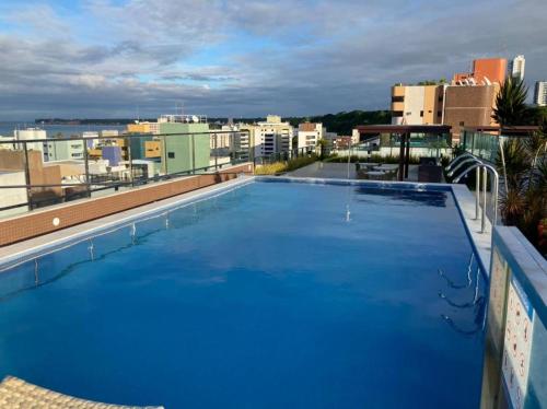 una gran piscina azul en la parte superior de un edificio en APARTAMENTO TEMPORADA - CABO BRANCO, en João Pessoa