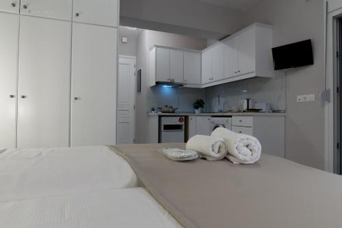 una cocina blanca con armarios blancos y toallas en Sunset brand new luxury apt with pool & sea view en Kárpatos