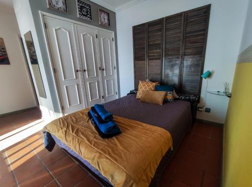 a bedroom with a bed with a blue backpack on it at Brisa do Mar da Vagueira in Praia da Vagueira