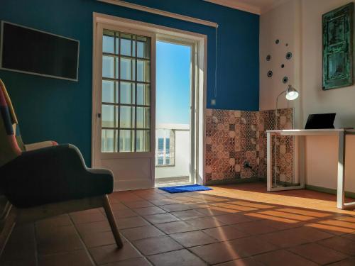 a room with an open door with a chair and a desk at Brisa do Mar da Vagueira in Praia da Vagueira