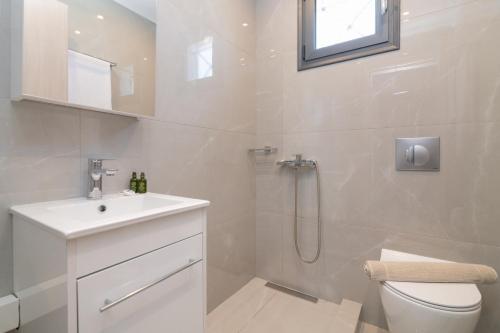 a bathroom with a toilet and a sink and a shower at Nimar Villa in Gaïtánion