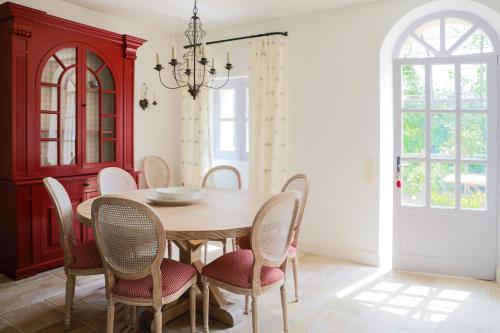 une salle à manger avec une table et des chaises en bois dans l'établissement Villa Pivoine - Château La Martinette, à Lorgues