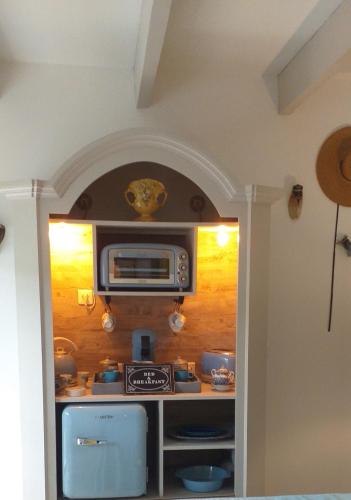 a kitchen with a microwave on a wall at LE PETIT JARDIN ... in LʼIsle-sur-la-Sorgue