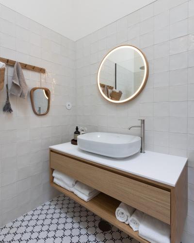 a white bathroom with a sink and a mirror at 4 bedroom Luxury Villa - riverside & beachside in Esposende