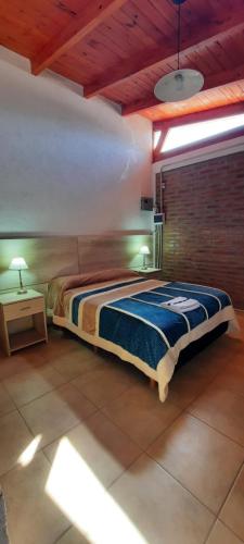1 dormitorio con cama y techo de madera en Cabañas El Aromo en 