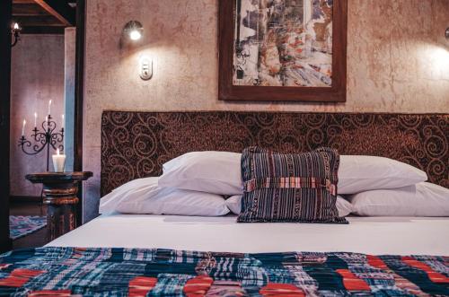 a bed with a pillow on it in a bedroom at Meson Panza Verde in Antigua Guatemala