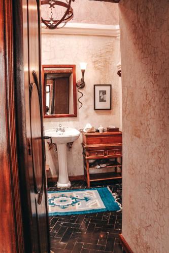 a bathroom with a sink and a mirror at Meson Panza Verde in Antigua Guatemala