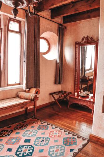 a living room with a bench and a mirror at Meson Panza Verde in Antigua Guatemala