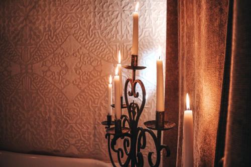 a candle holder with two candles in front of a wall at Meson Panza Verde in Antigua Guatemala