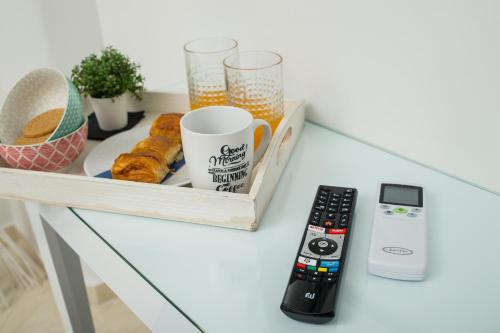 a table with a tray of food and a remote control at Lux VIP Apartments in Perea