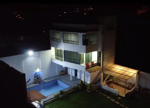 a large white building with a swimming pool at night at Villa blanca in Andahuaylas