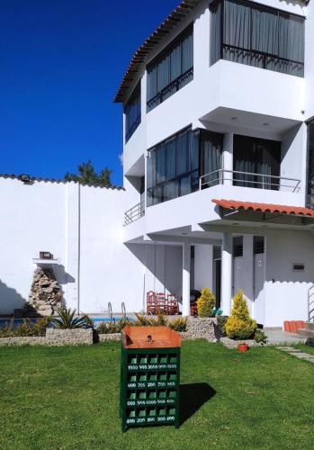 un bâtiment blanc avec un panneau devant lui dans l'établissement Villa blanca, à Andahuaylas