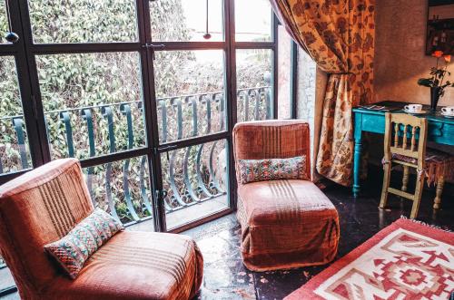 a living room with two chairs and a window at Meson Panza Verde in Antigua Guatemala