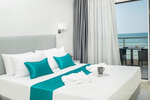 a hotel room with a bed with blue and white pillows at Lux VIP Apartments in Perea