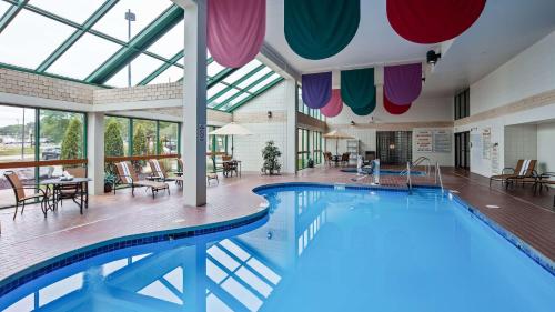 a swimming pool in a building with a large window at Best Western East Towne Suites in Madison