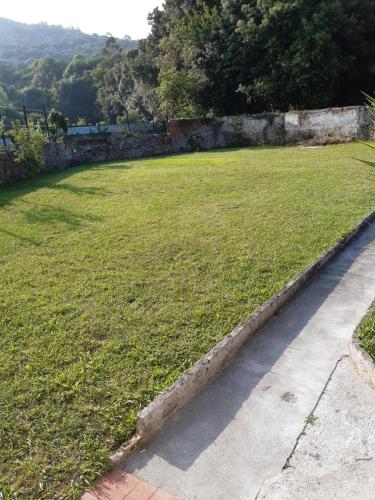 a grassy yard with a stone wall and a grass field at Casa en Laredo in Laredo